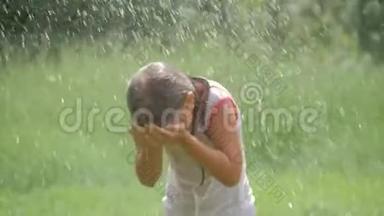美丽的女孩在花园里泼水的肖像。 女孩完全湿透了，这`是非常炎热和快乐的一天。 概念